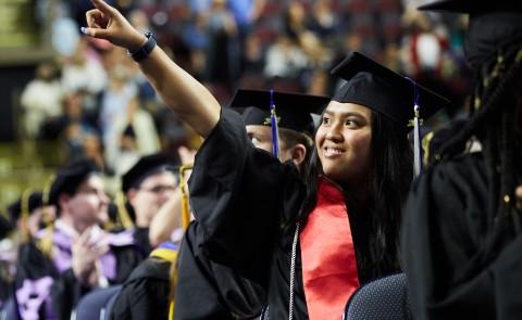 A student points to the crowd during the 187th Commencement ceremony at the Cross Insurance Arena in Portland